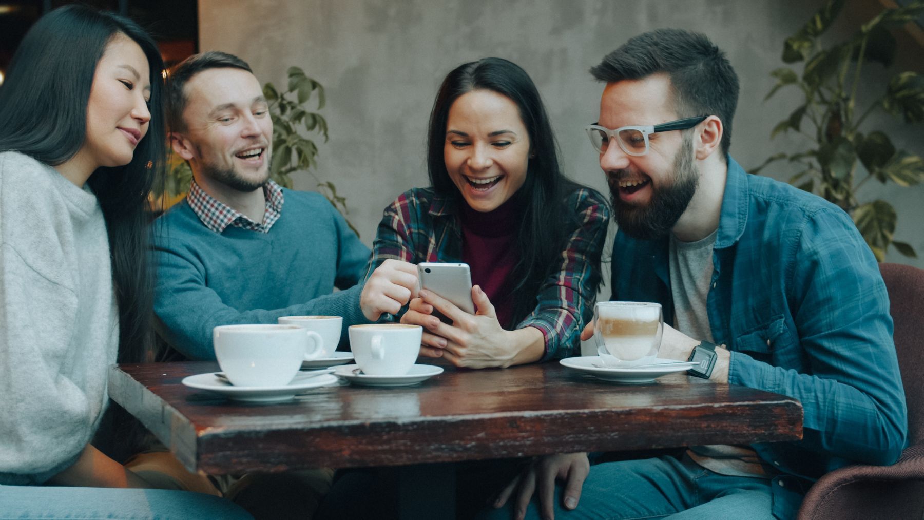 Friends laughing around a café table